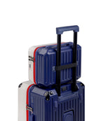 Two suitcases, one blue and one white with red accents, stacked on a white background.